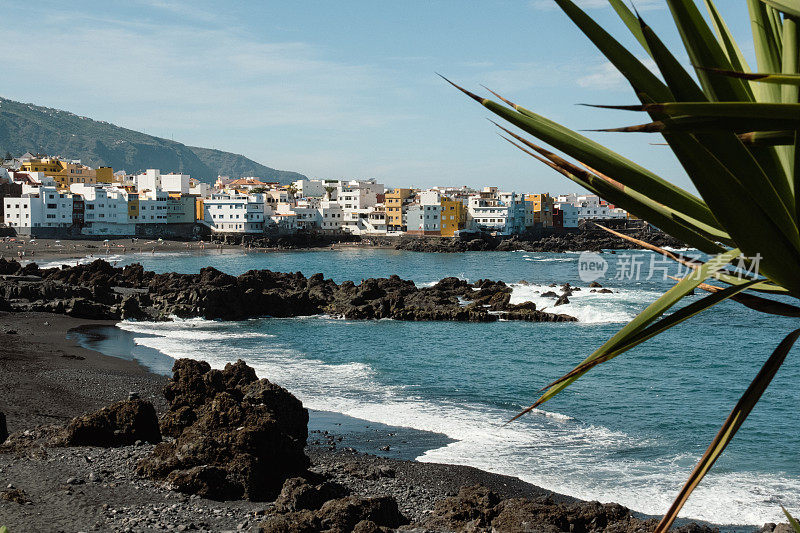 美丽的海滩，黑色的沙滩和黑色的火山岩。靠近海洋的热带度假城市的景色。普拉亚花园，Puerto de la Cruz，西班牙特内里费岛